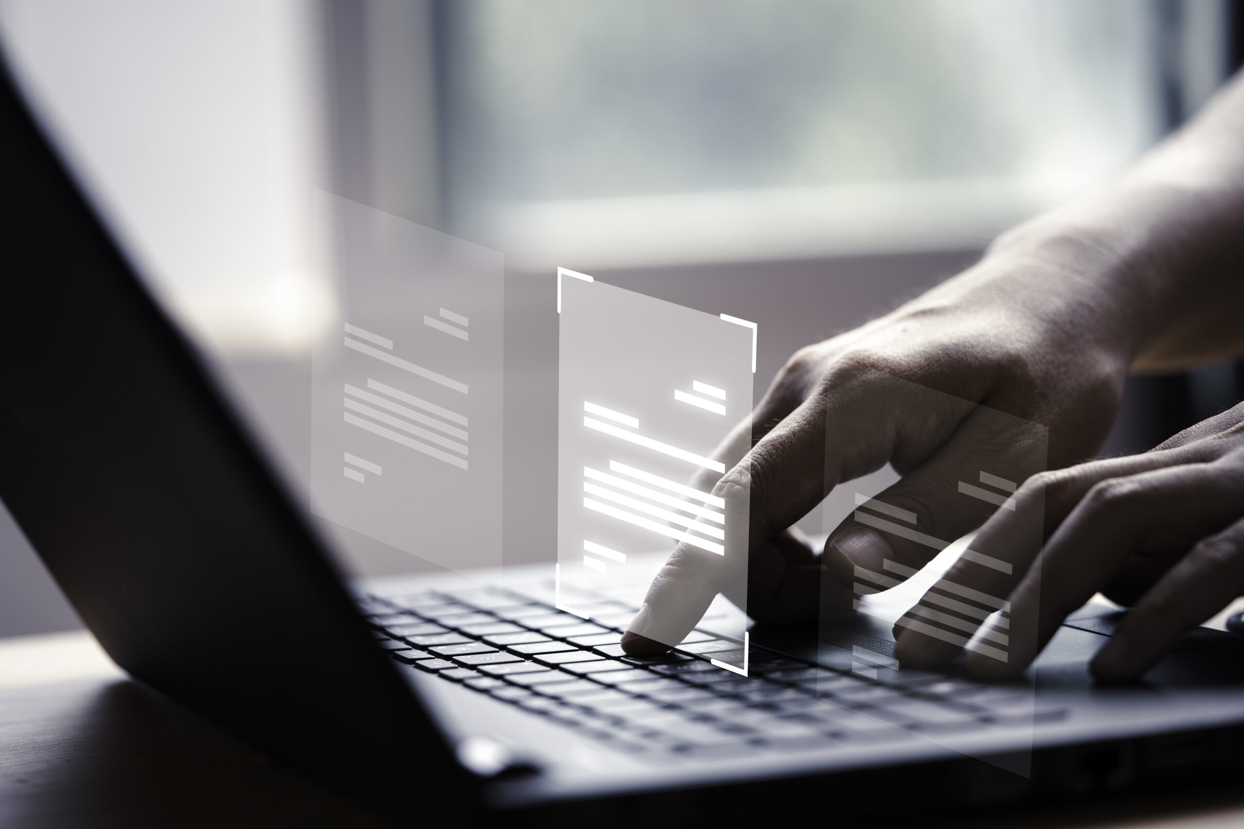 Hands typing on a laptop keyboard with floating digital documents above, conveying a sense of technological interaction and productivity.
